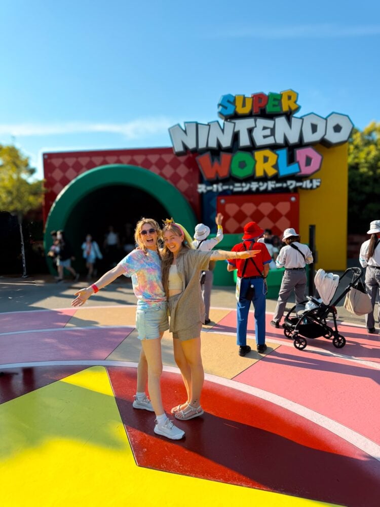 Sisters posing for photo at pipeline entrance of Super Nintendo World in Universal Studios Japan.